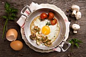 Fried egg with mushrooms and tomatoes