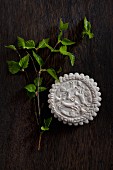 Aniseed biscuit with moulded hare motif and young birch twig on wooden table