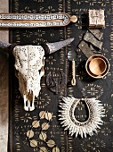 African jewellery, home accessories made from natural materials and animal skull on dark runner with small graphic pattern