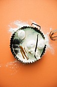 Baking ingredients – flour, eggs, cinnamon sticks and vanilla pods in a baking tin