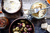 Italienische Antipasti: Eingelegte Oliven, Artischockenherzen, Bohnendip und getrocknete Tomaten