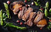 Roast duck with pomegranate seeds and asparagus