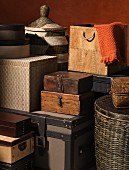 Stacked storage containers made from various materials such as wicker, wood, cardboard and leather crammed together in small space