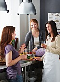 Three friends in a kitchen with drinks