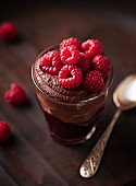 A layered dessert with chocolate-brandy mousse, cherry sauce and raspberries