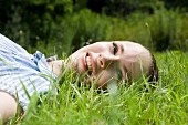 Junge Frau liegt im Gras