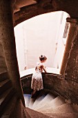 A woman leaning on a staircase balustrade and looking out