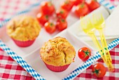 Muffins mit Bratwurst und Sauerkraut auf Tablett; Tomaten und Plastikgabel