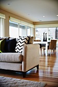 Bright, modern living-dining room with wooden floor and rug