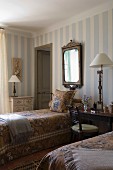 Charmantes Gästeschlafzimmer mit antiken Landhausmöbeln und pastellfarbener Streifentapete
