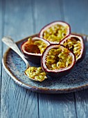 Halved passion fruits on a ceramic plate