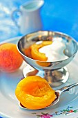 Peaches with cream in a silver dish