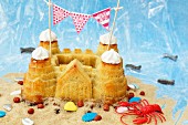 A sandcastle cake with beach decorations