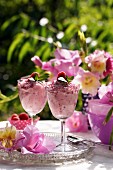 Himbeermousse und Gladiolenblüten auf sommerlichem Gartentisch