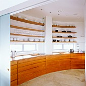 Cherry wood base cabinets and shelves on curved wall in penthouse apartment