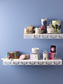 Various scented candles on metal shelves with punched trim