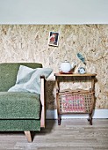 50er Jahre Sofa und Retrotisch mit Zeitungshalter vom Secondhandmarkt, dahinter rustikale Wandverkleidung aus OSB-Platten
