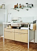 Moderner Küchen Spültisch mit Metallgestell und Holz Schubladen, an Wand Glasablage mit Küchenutensilien
