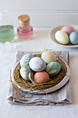 Eggs in pastel colours in Easter nest