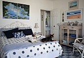 Hunde auf Tagesdecke mit weiss-blauem Punktemuster in ländlich-maritimen Schlafzimmer