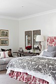 Schlafzimmer im traditionellen französischen Stil mit Toile-de-Jouy Mustern und klassischer Leuchte auf antikem Beistelltisch