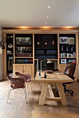 Leather office chair at solid wooden table in front of illuminated bookcase