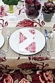 A place setting with a red and white fabric napkin