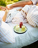 Kinder mit Fruchtsäften beim Frühstück im Bett auf der Wiese