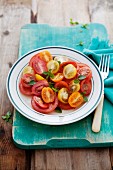 Tomato salad made with three different types of tomatoes and garnished with basil