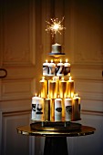 Moderner Christbaum aus pyramidenförmig arrangierten weissen und goldenen Kerzen mit Wunderkerze auf der Spitze