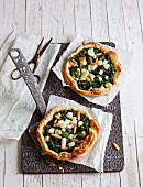 Spicy puff pastry tartlets with spinach and pine nuts
