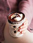 A woman holding a mug of hot chocolate
