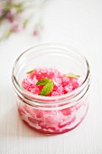 A jar of pomegranate sorbet with mint