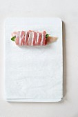 Raw chicken breast with sage wrapped in bacon