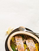Salmon fillets on vegetables in a steamer basket