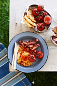 Corn cakes with fried bacon and tomatoes