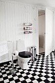 Chequered floor in rustic bathroom with white wood-clad walls