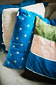 Stack of scatter cushions with patterns of stripes and stars