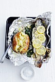 Foil-wrapped trout filled with spinach and a baked potato