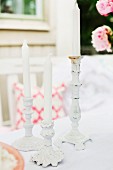 weiße Vintage Kerzenhalter mit weissen Kerzen in romantischem Outdoor Ambiente