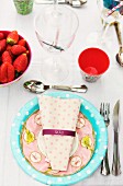 Pastel patterned paper plate and napkin on place setting for garden party