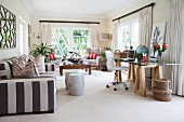 Modern desk in work area and striped sofa in exotic living room