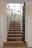 Stairwell with wrought iron gate and sisal carpet