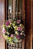 Vintage-style wreath of flowers and succulents on door