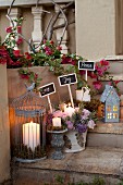 Stone steps festively decorated with lit candles in lanterns and flower arrangements