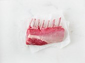 Raw rack of lamb on a piece of parchment paper