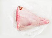 Raw leg of lamb on a piece of parchment paper