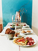 A table laid with pancakes, ham and crispbread