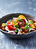 Summer salad with tomatoes, herbs, cucumber and red onion