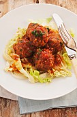 Sweet and sour chicken meatballs with chilli sauce on a bed of salad
